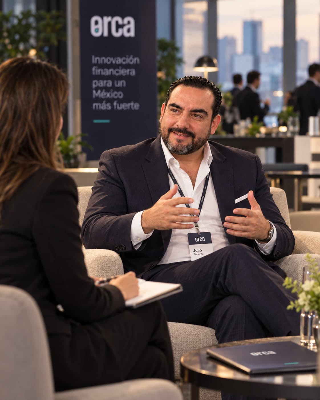 Julio Ortiz Mena conversa con una entrevistadora en un encuentro de Orca, con la ciudad al fondo